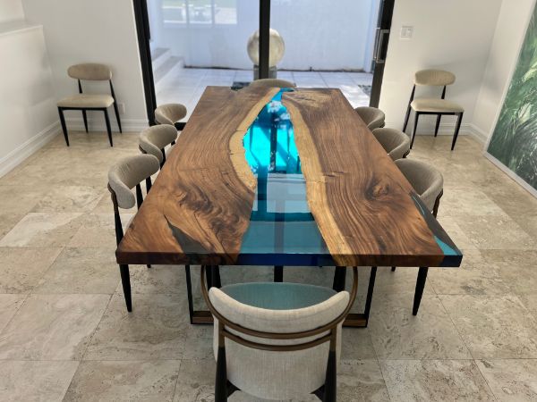 Handcrafted dining table with blue epoxy resin river, live edge walnut wood, modern design for luxury homes